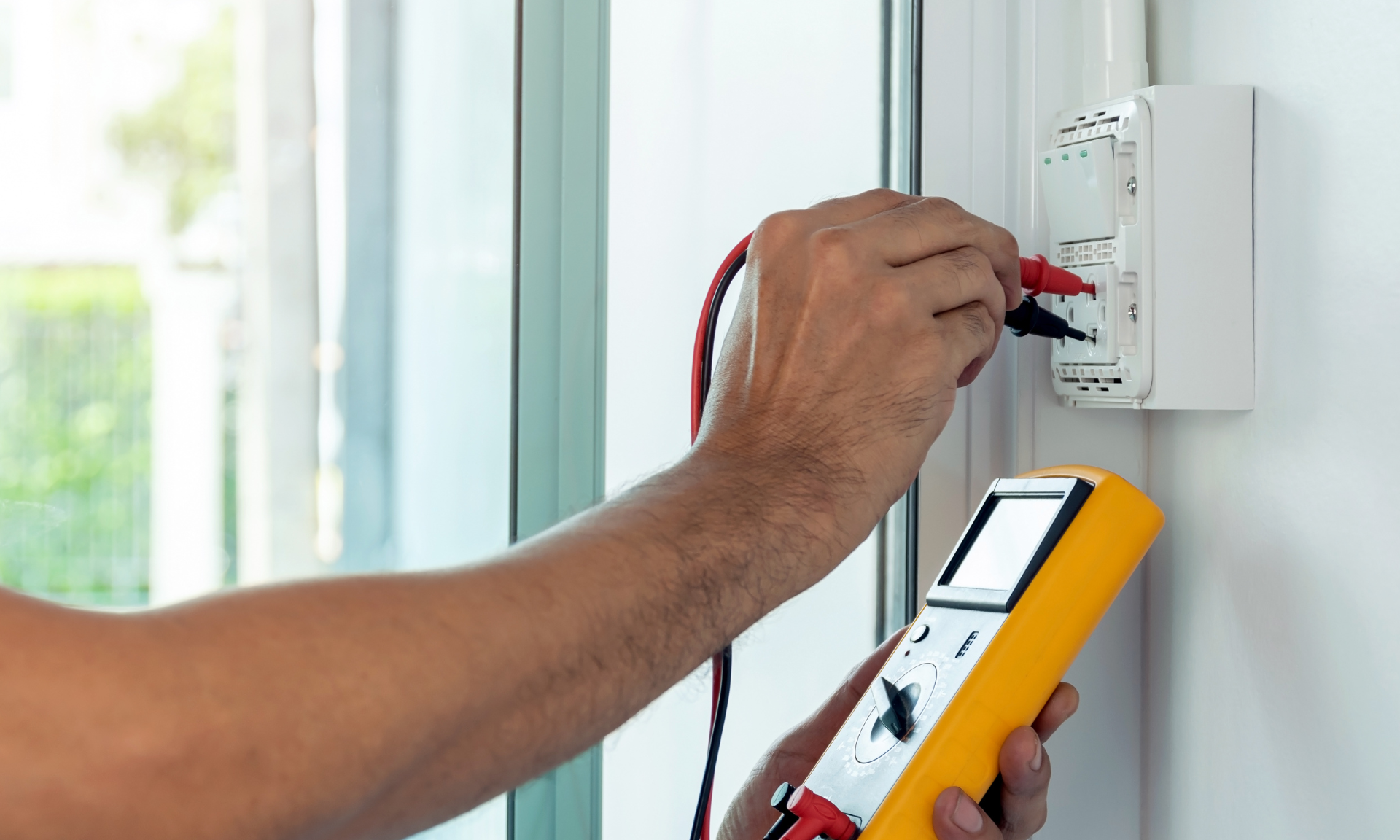 un électricien qui installe une prise