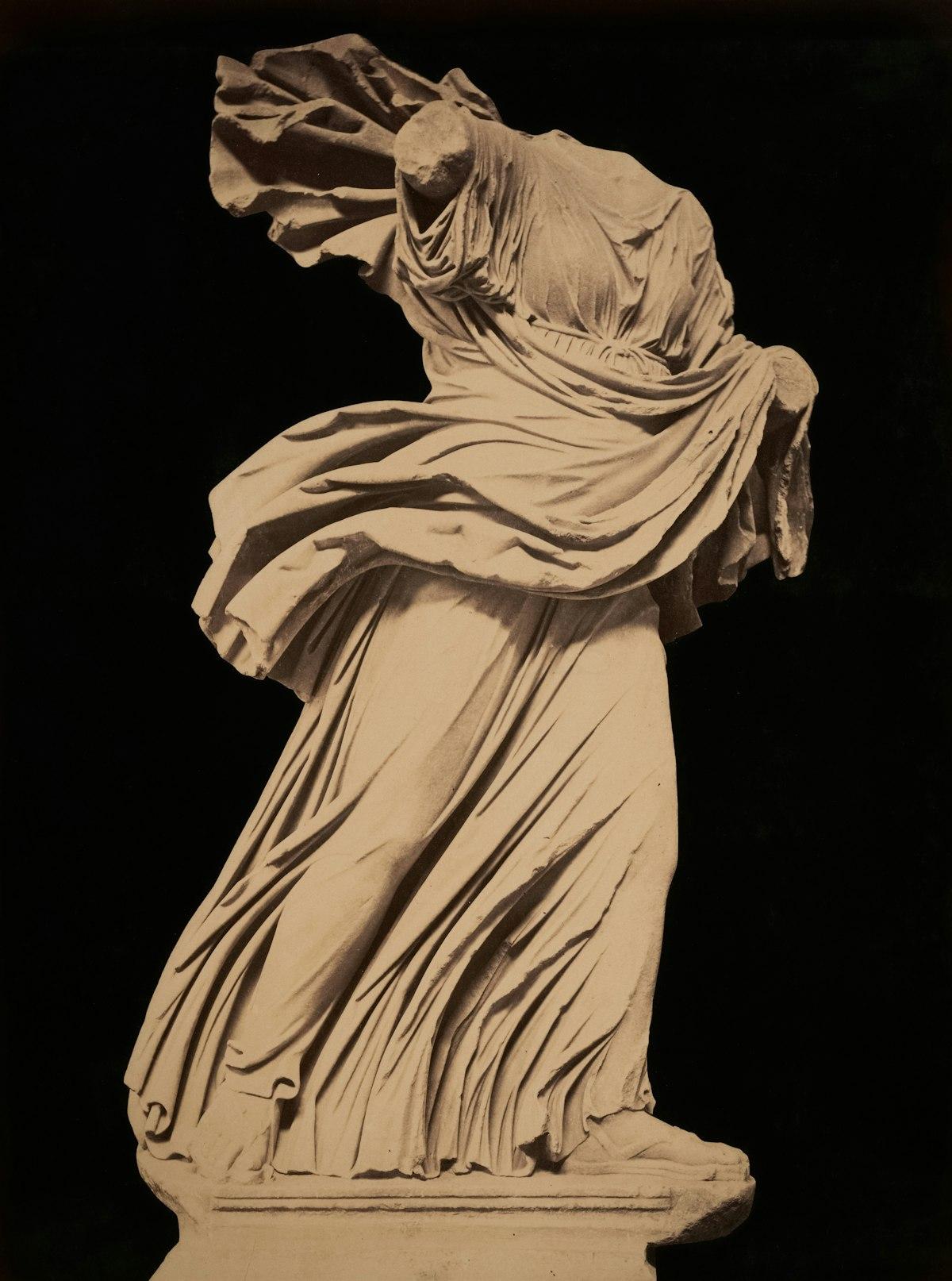 Photographie sépia d'une statue de marbre drapée servant de modèle